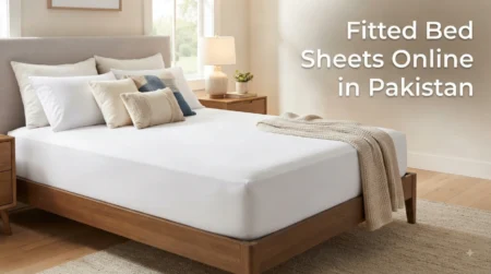 Fitted bed sheets online in Pakistan featuring a modern, clean bedroom setup with a white fitted sheet, decorative pillows, and wooden bed frame.
